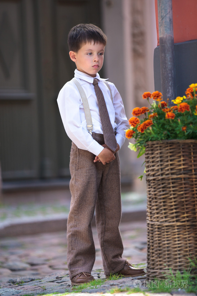 一个可爱的小男孩户外在城市中的肖像