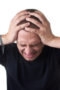 绝望隔离绝望的年轻人在他的手紧紧地抱头.在白色隔离照片