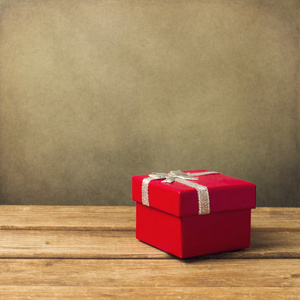 在木桌上的红色小礼品盒