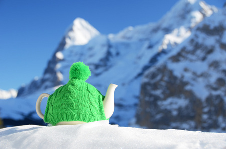 针对山山顶雪上的针织帽茶壶