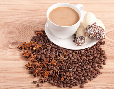 杯咖啡，咖啡豆，木制的背景上糖果上茴香