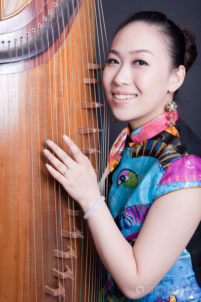 年轻妇女和中国古筝演奏