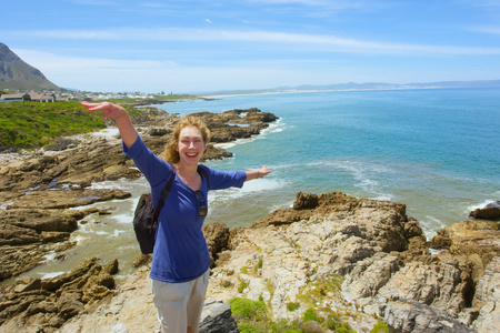 笑的女人站在陡峭的岩石上