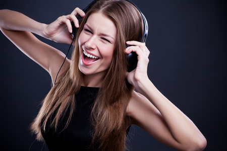 年轻漂亮的女人享受音乐头戴式耳机