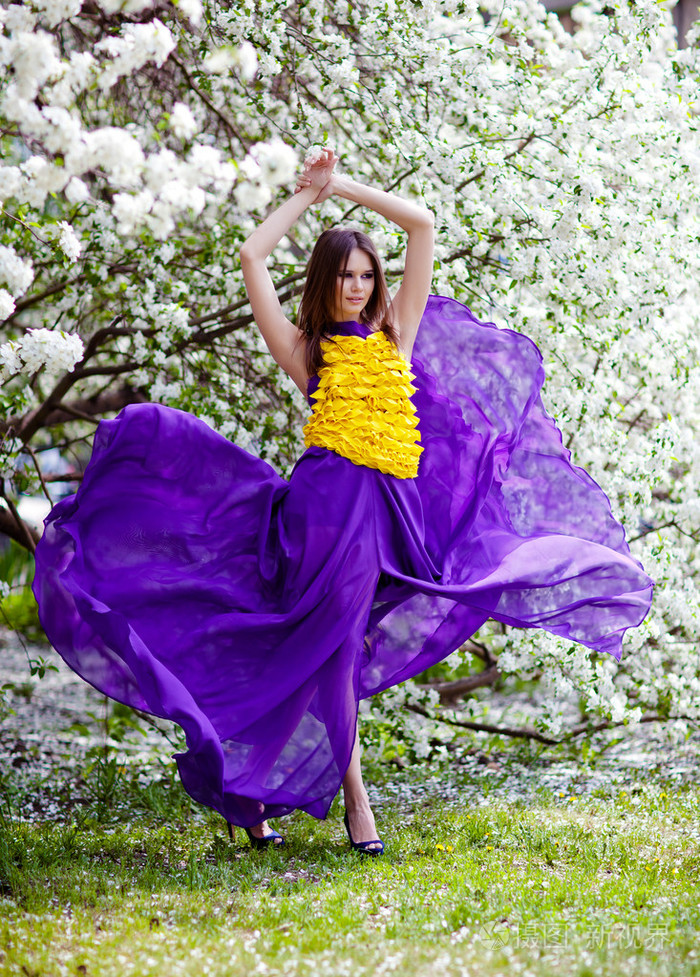 美丽的女人苹果树林中飘动的裙摆