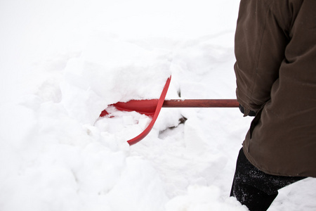 男子用铁铲除雪