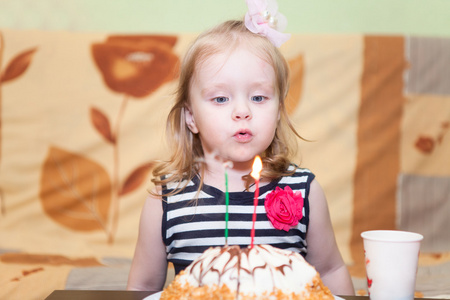 吹蜡烛的生日蛋糕上的小高加索女孩
