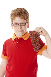 健康饮食。白种人的小男孩，抱着一堆新鲜葡萄
