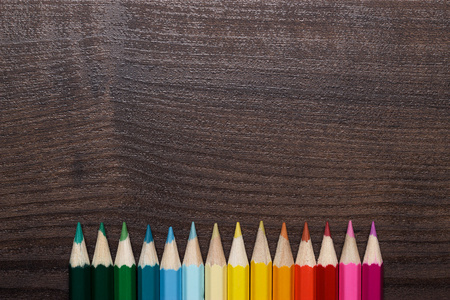 五彩的铅笔在棕色木桌