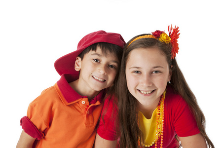 真实。微笑的白种人的哥哥和妹妹穿着鲜艳的红色和橙色服装