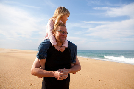 父亲在海滩上肩上背的女儿图片