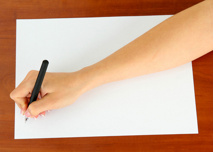 手带支笔在白皮书，木制背景上