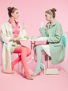 喝茶的两个女孩金发五十年代时尚风格