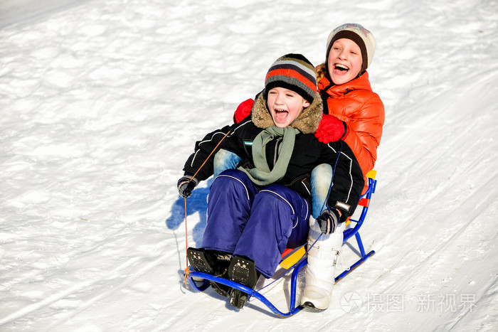 小男孩和女孩在雪橇冬季