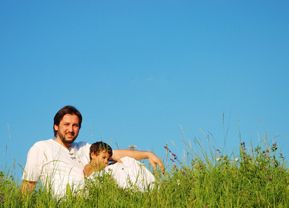 年轻的父亲在白色与美丽草原上的孩子