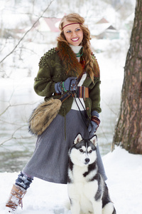 快乐的年轻女人站在西伯利亚爱斯基摩狗