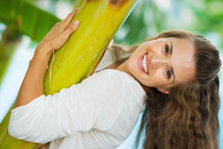 年轻女人放松之间热带棕榈树。后视图