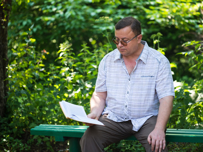 轻松休闲的男人坐在公园和阅读
