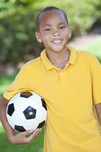 非洲裔美国男孩儿童玩足球或足球球