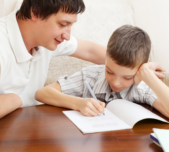父亲帮助儿子做作业照片
