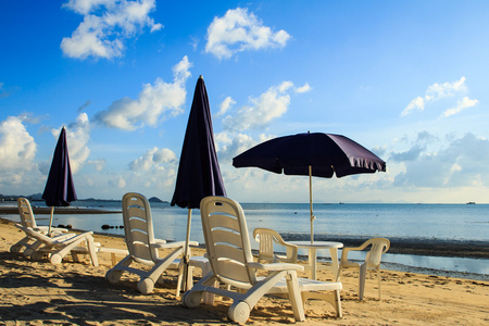 沙滩椅和美丽的热带沙滩上的遮阳伞