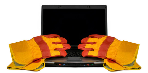 孤立的便携式计算机上的防护手套。为空黑色桌面