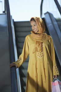 站在自动扶梯上的穆斯林女人