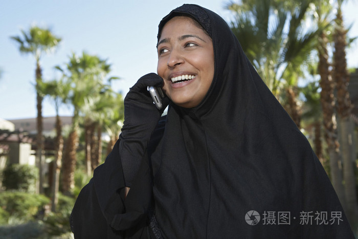 使用手机的黑色头巾的穆斯林妇女