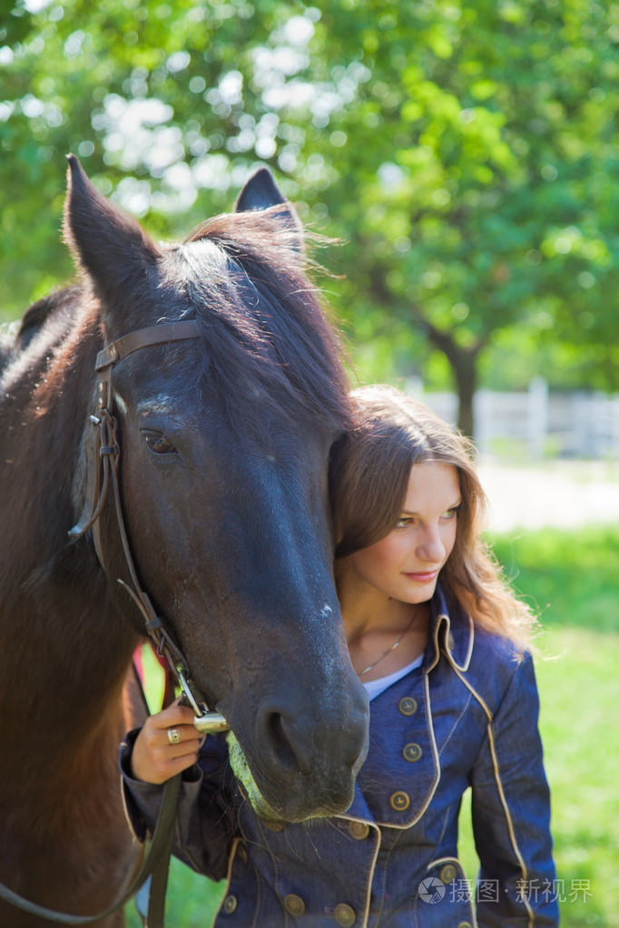 一个年轻的女孩与一匹马的画像把重点放在马的脸上