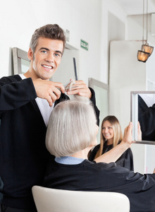 在沙龙美发师切割客户的头发图片