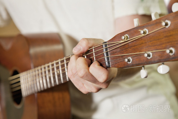 弹吉他的人的手的特写视图