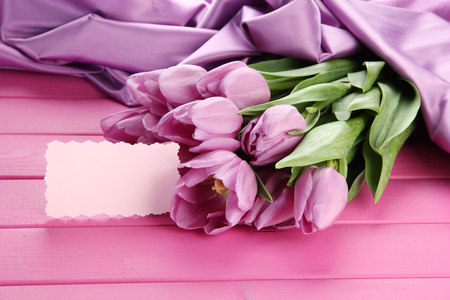 束美丽的紫色郁金香粉色木制背景上