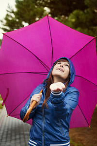 年轻女子在粉红色的雨伞下