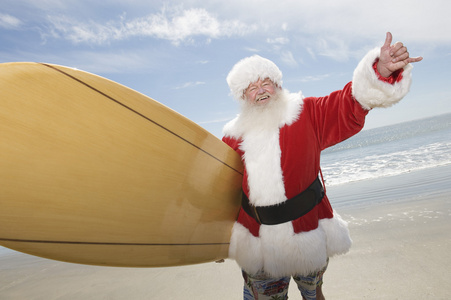 圣诞老人与海滩上的冲浪板