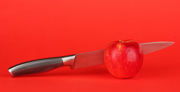 红苹果和刀上红色背景