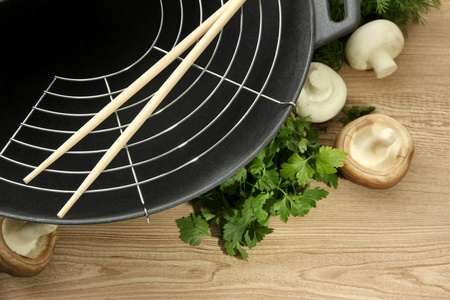 黑炒锅和厨房木桌子上的蔬菜 关门