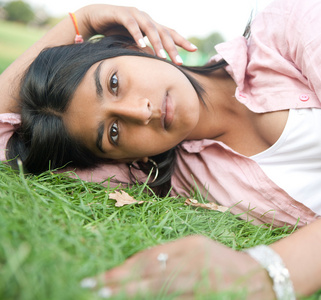 少女在公园里的绿色草地上休息