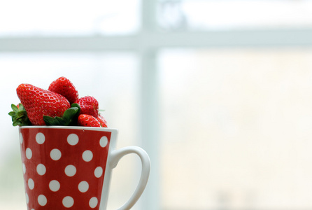 草莓在杯中的附近的窗口
