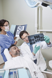 牙科医生向病人解释 x 射线报告