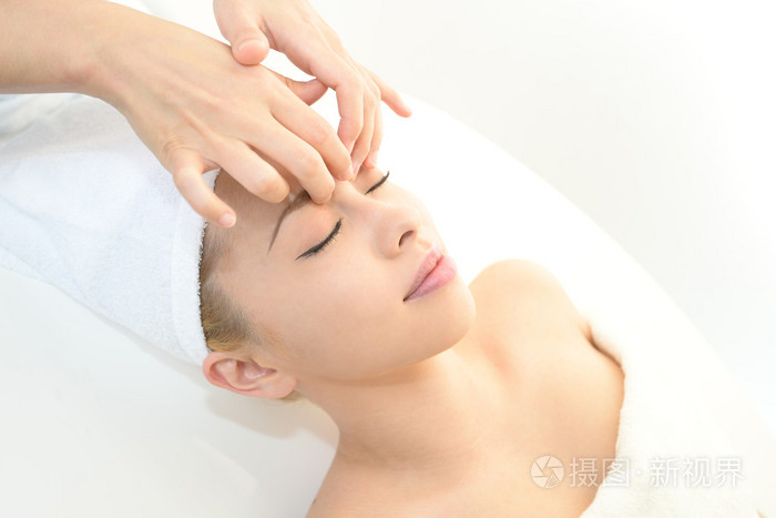 美丽的年轻女子接受面部按摩