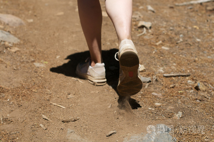 中心附近起来的女人的脚在泥土徒步旅行