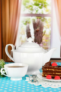 茶壶 杯茶和美味的蛋糕上窗口背景