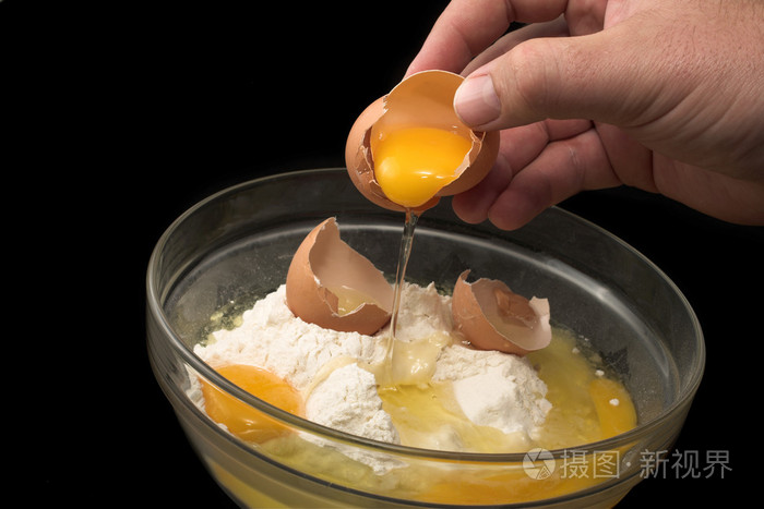 打破一个鸡蛋入一个玻璃碗用面粉的手