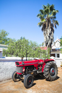 老红色拖拉机站在一个农场围场