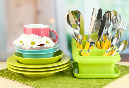 板 叉 刀 勺和其他厨房器具上彩色餐巾纸，在明亮的背景上