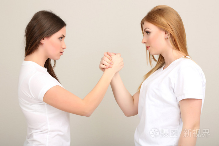 灰色背景上的两个女孩朋友争吵