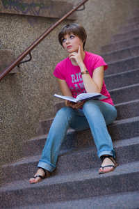 十几岁的女孩在楼梯上的书