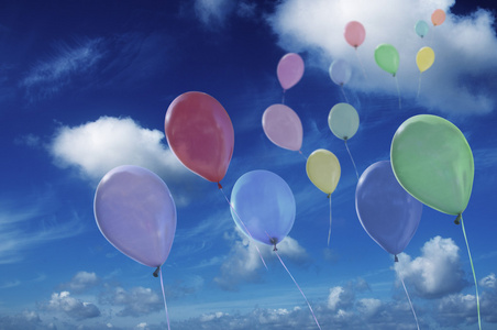 彩色的气球反对多云的天空