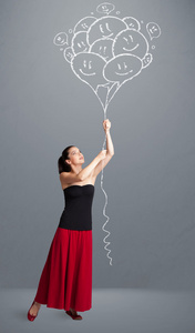 快乐的女人举行微笑气球绘图