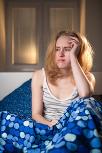 年轻白种女人躺在床上与头痛抑郁和宿醉